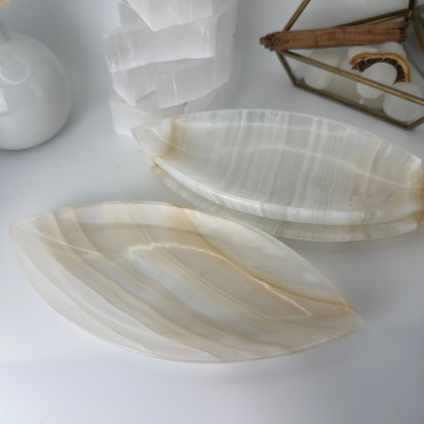 Two onyx stone coasters on a white surface with a blurred background