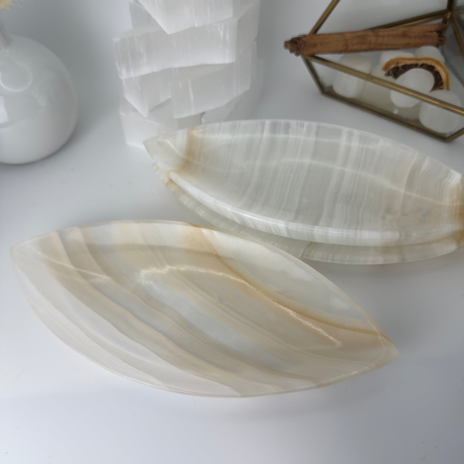 Two onyx stone coasters on a white surface with a blurred background